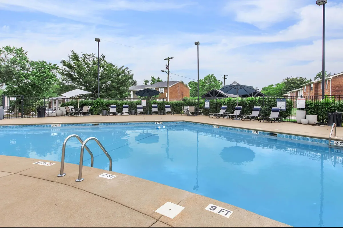 An inviting outdoor swimming pool area with lounge chairs and umbrellas, set in a tranquil environment. The mood is leisurely and relaxing, ideal for unwinding after exploring the city or local attractions.
